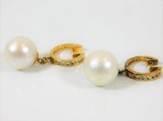 A pair of 18ct gold pair of diamond & 13mm pearl e