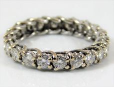 A white metal eternity ring, tests as 18ct gold, s