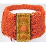 A 19thC. woven coral bracelet set with yellow meta