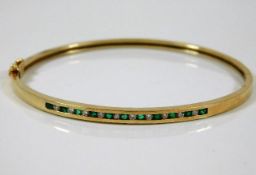 A 10ct gold bangle set with diamond & emerald 8.3g