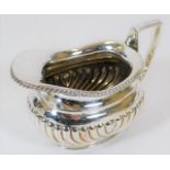 A white metal creamer with gadrooned sides 130g