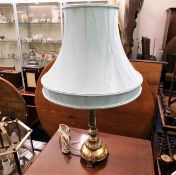 A decorative brass table lamp with shade