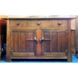 An arts & crafts style oak sideboard with three dr
