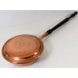 An early 19thC. copper warming pan with ebonised h