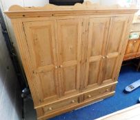 A large waxed pine double wardrobe with drawers un