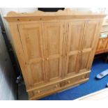 A large waxed pine double wardrobe with drawers un