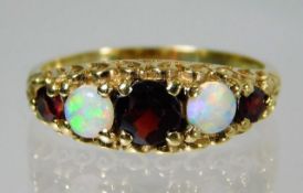 A 9ct gold ring set with opal and garnet 3.1g Size