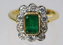 An 18ct gold ring set with emerald and diamonds 4.6g Size G