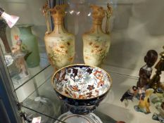 A pair of decorative porcelain ewers twinned with