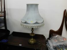 Decorative brass table lamp with fringed shade