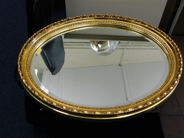 Oval gilt framed mirror twinned with one other mir