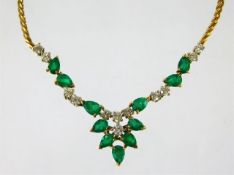 An 18ct gold necklace set with emeralds & diamonds