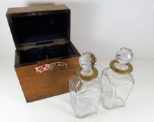 An oak cased decanter set with brass collars, box