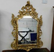 An ornate reproduction gilt framed mirror 50in wid