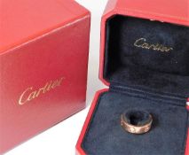 A Cartier rose gold love ring set with three diamo