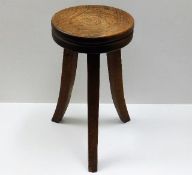 A stylised low level oak stool with flared legs 19