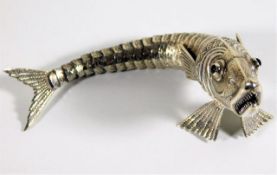 A white metal reticulated fish with red stone eyes