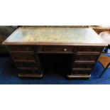 An antique mahogany knee hole desk with nine drawers