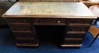 An antique mahogany knee hole desk with nine drawers