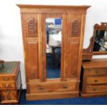 A c.1900 walnut wardrobe with centre mirror & carv