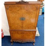 A mid 20thC. drinks cabinet with carved frieze between cabriole legs & carved finial 64inH x 36.25in