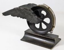 A desk thermometer mounted on bronze winged wheel