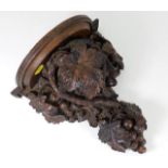 An antique carved oak wall sconce depicting grapes