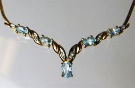 A 9ct gold necklace set with blue topaz & diamonds