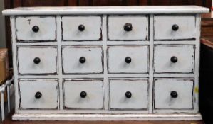 A painted chest of twelve drawers with handles originally from the family home of artist Peter Lanyo