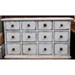 A painted chest of twelve drawers with handles originally from the family home of artist Peter Lanyo