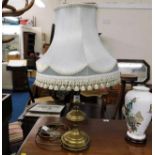 A decorative brass lamp with shade