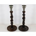 A pair of metal topped oak barley twist candlestic