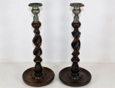 A pair of metal topped oak barley twist candlestic