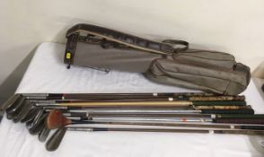 A quantity of vintage golf clubs with bag