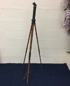 An antique tripod with brass fittings