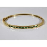 A 10ct gold bangle set with emerald & 0.2ct diamon
