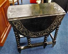 An ebonised oak drop leaf table