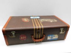 A vintage lined suitcase with Cunard White Star RMS Mauretania labels