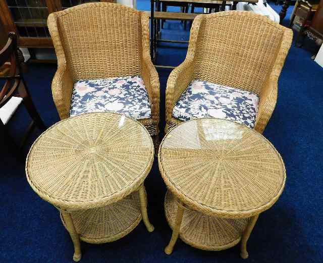 A pair of wicker chairs with matching tables