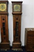 A brass faced longcase clock with rustic arts & cr