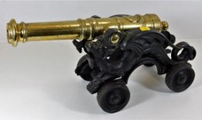 A large decorative brass table cannon with ornate