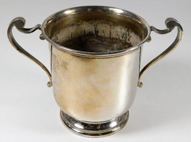 A silver two handled loving cup with base rim insc