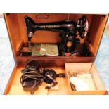 A cased Singer sewing machine with accessories