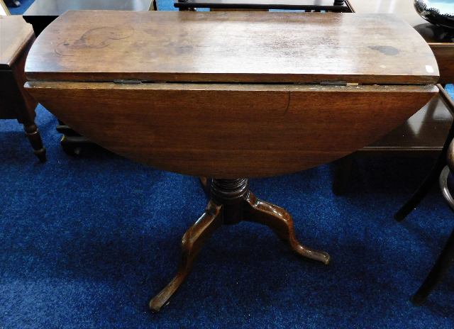 An oak pedestal table with drop leaves 33.25in W x