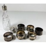 Six silver napkin rings, a silver topped jar & a s