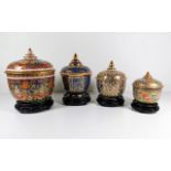 Four hand painted Oriental ginger jars with carved stands