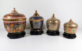 Four hand painted Oriental ginger jars with carved stands