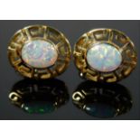 A pair of 14ct gold earrings set with opal style s