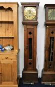 A brass faced longcase clock with rustic arts & cr