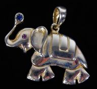 A yellow metal elephant pendant set with sapphire